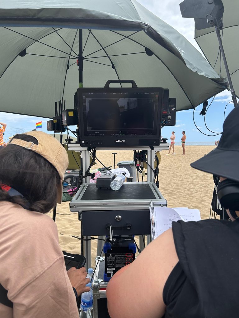 Outdoor beach film set with professional equipment and crew